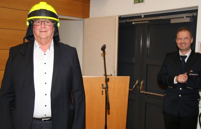Zum Abschied gibt es für Bürgermeister Peter Schäfer einen Feuerwehrhelm. Rechts Kommandant Frank Sattler.