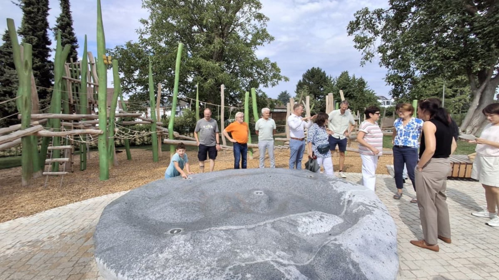 Stadträte bewundern den Wasser spritzenden Granitblock. Im Hintergrund ein Teil des Spielplatzes.Sabine Armbruster Stadträte bewundern den Wasser spritzenden Granitblock. Im Hintergrund ein Teil des Spielplatzes.Sabine Armbruster