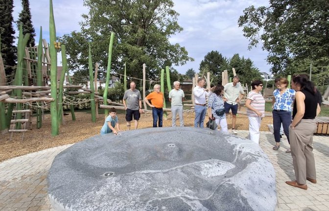 Stadträte bewundern den Wasser spritzenden Granitblock. Im Hintergrund ein Teil des Spielplatzes.<span class='image-autor'>Sabine Armbruster</span>