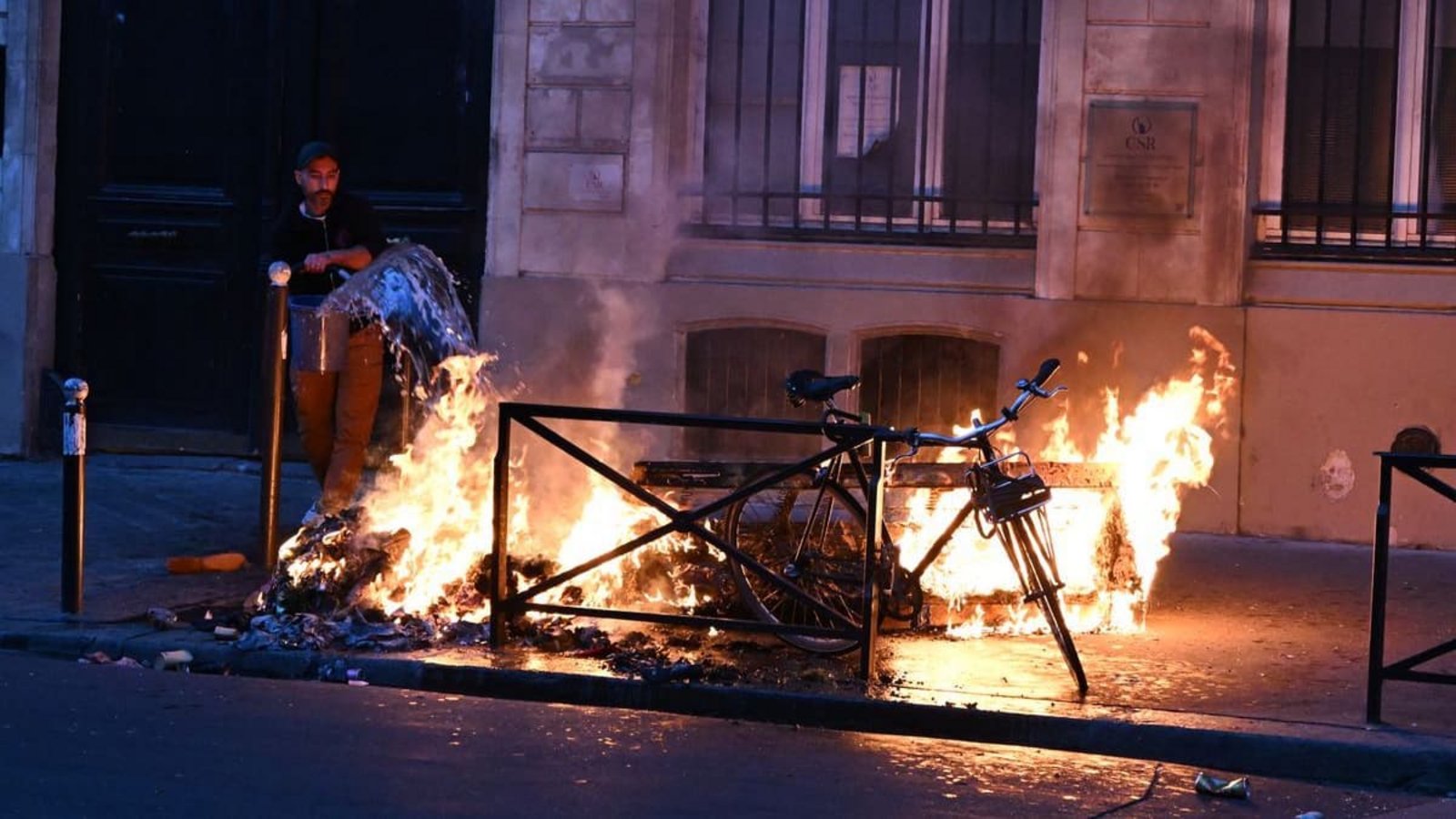 Ein Mann versucht in Paris, während der Zusammenstöße zwischen Demonstranten und Polizeibeamten ein Feuer zu löschen.Foto: Emma Da Silva/AP/dpa