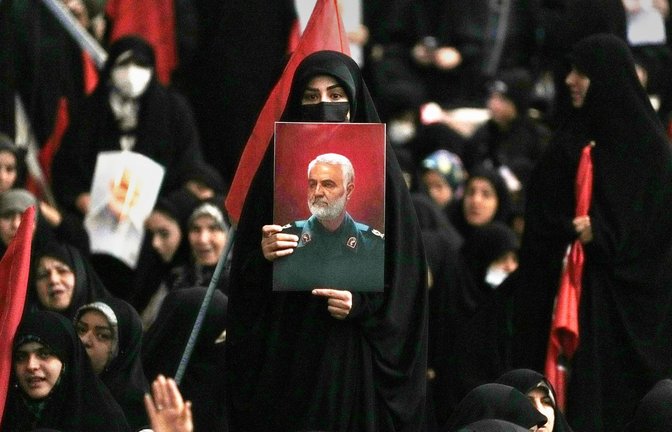 Eine Frau zeigt während einer Gedenkfeier  in der großen Imam-Khomeini-Moschee in Teheran ein Bildnis des 2020 im Irak getöteten Qassem Soleimani.<span class='image-autor'>Foto: Vahid Salemi/AP/Vahid Salemi</span>