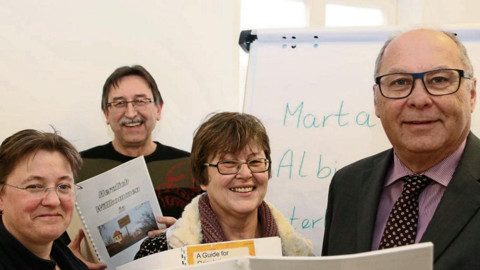 Karin Großkopf, Rolf Regener, Pfarrerin Elke Gratz und Bürgermeister Werner Somlai zeigen die Willkommensbroschüre. Foto: Bögel