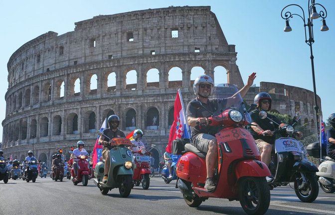 Vespa-Fans fahren am Kolosseum vorbei.<span class='image-autor'>Foto: Alessandra Tarantino/AP/dpa</span>