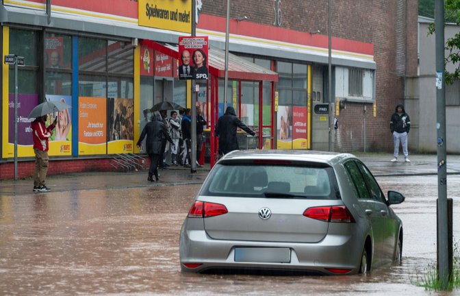 Passanten stapfen und fahren durch das Hochwasser  in Saarbrücken.<span class='image-autor'>Foto: dpa/Harald Tittel</span>