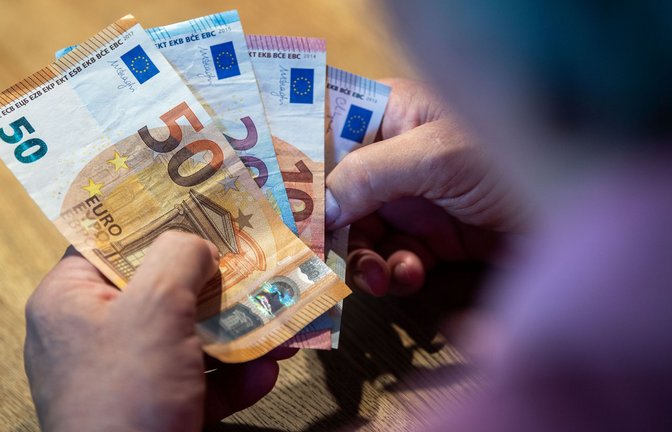 Ein älterer Mann sitzt an einem Tisch und zählt Geld.<span class='image-autor'>Foto: dpa/Lino Mirgeler</span>