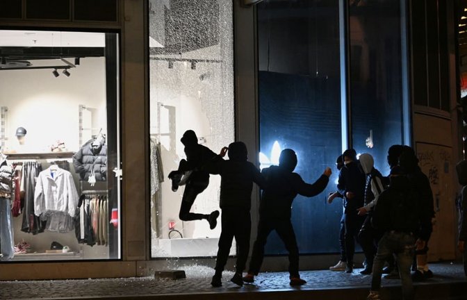 Proteste in Frankreich: Jugendliche zerschlagen bei Zusammenstößen zwischen Demonstranten und der Polizei in Paris eine Schaufensterscheibe.<span class='image-autor'>Emma Da Silva/AP/dpa</span>