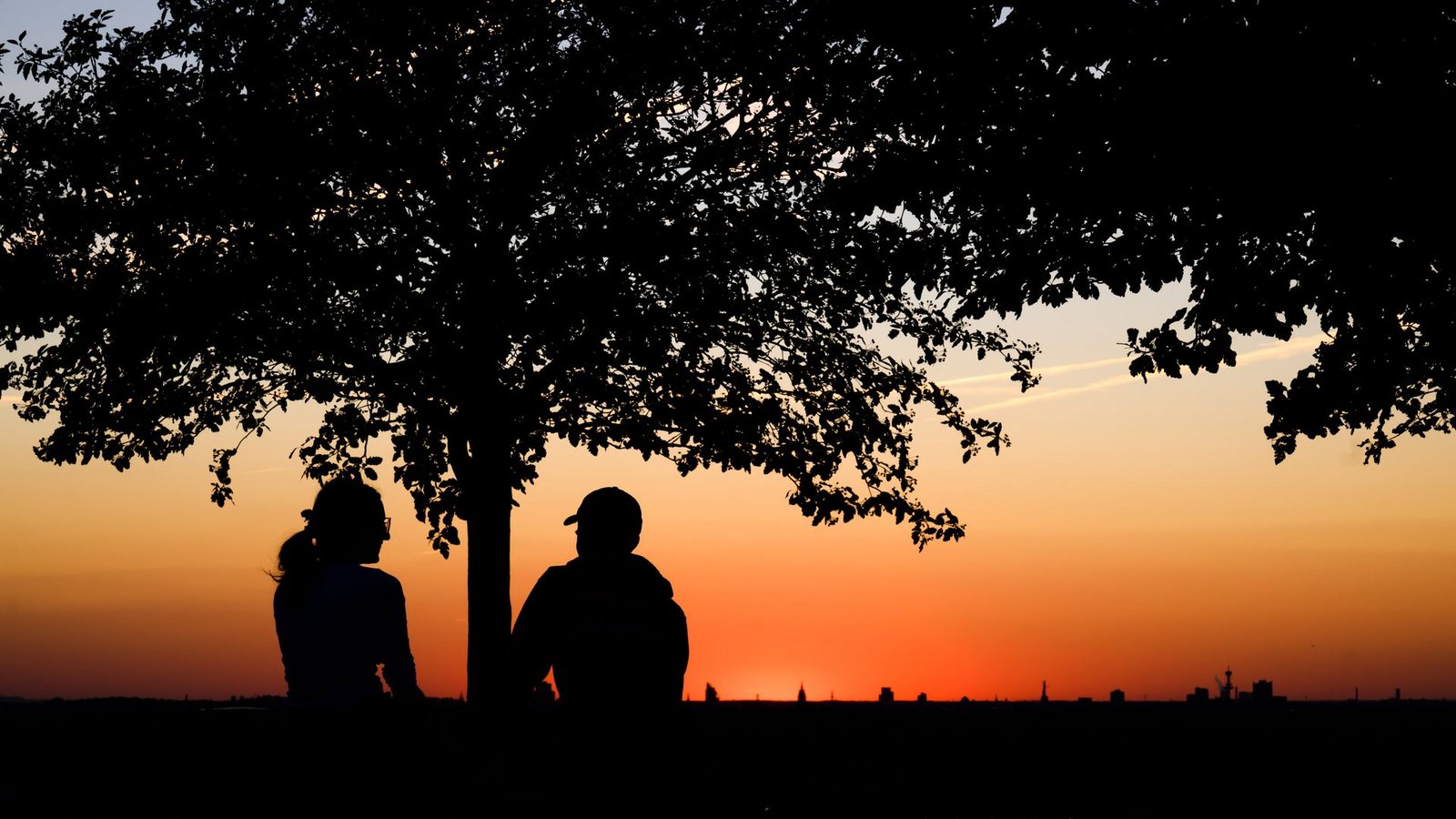 Ein Paar genießt kurz nach Sonnenuntergang auf dem Kronsberg in Hannover das sommerliche Wetter.Foto: Julian Stratenschulte/dpa