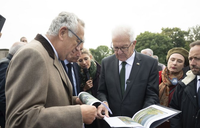 Am Hartmannswillerkopf übergibt Winfried Kretschmann dem Präsidenten des Nationaldenkmals, Jean Klinkert, Skizzen des Bergs, gefertigt vom Bruder der Großmutter seiner Frau, der im Ersten Weltkrieg in den Gefechten dort gefallen ist.<span class='image-autor'>Foto: Marijan Murat/dpa</span>