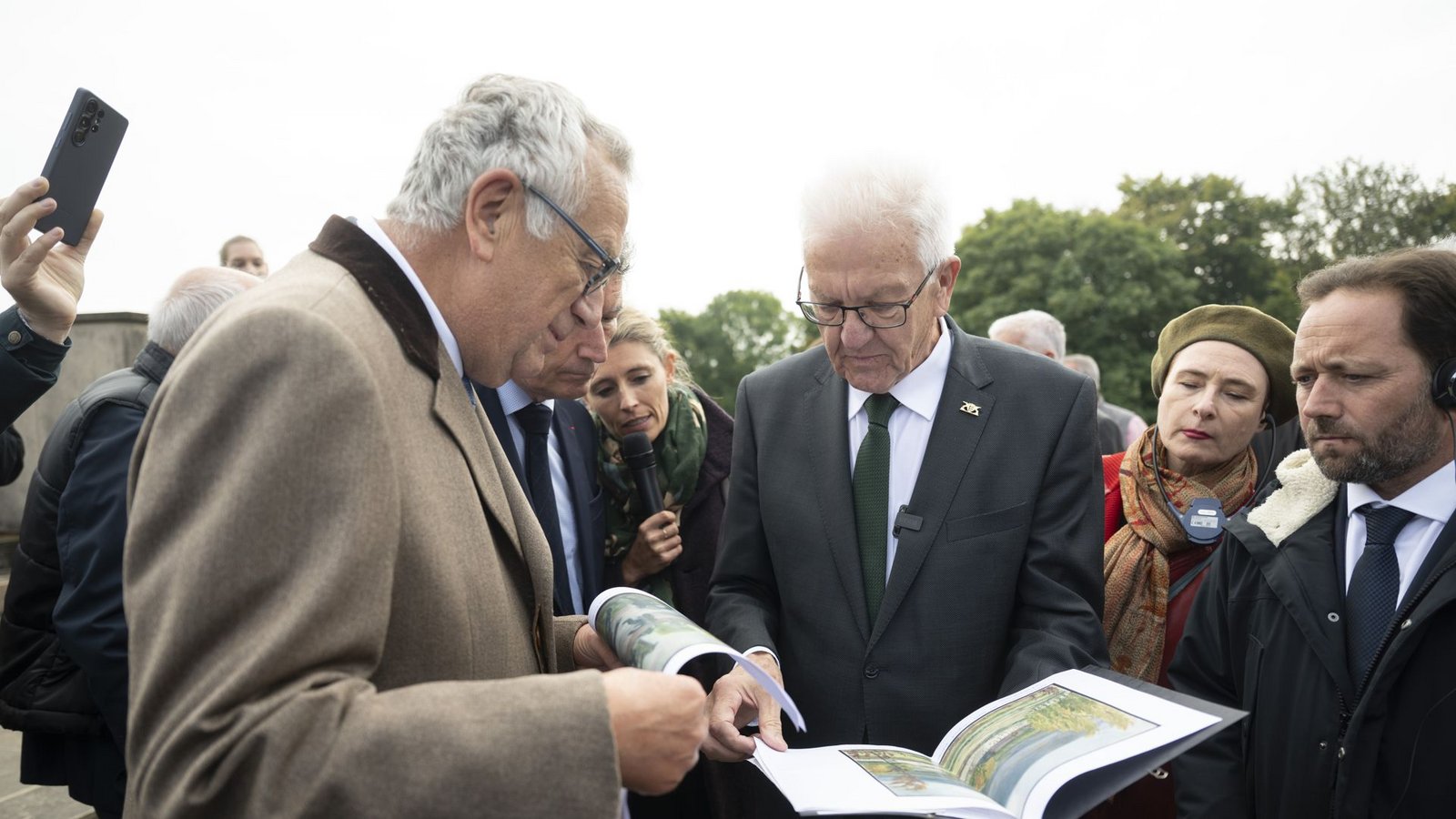 Am Hartmannswillerkopf übergibt Winfried Kretschmann dem Präsidenten des Nationaldenkmals, Jean Klinkert, Skizzen des Bergs, gefertigt vom Bruder der Großmutter seiner Frau, der im Ersten Weltkrieg in den Gefechten dort gefallen ist.Foto: Marijan Murat/dpa Am Hartmannswillerkopf übergibt Winfried Kretschmann dem Präsidenten des Nationaldenkmals, Jean Klinkert, Skizzen des Bergs, gefertigt vom Bruder der Großmutter seiner Frau, der im Ersten Weltkrieg in den Gefechten dort gefallen ist.Foto: Marijan Murat/dpa