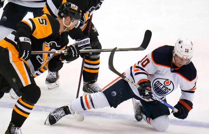 Derek Ryan (r) von den Oilers fällt nach einem Zusammenstoß mit Penguins' Mike Matheson auf das Eis.<span class='image-autor'>Foto: Gene J. Puskar/AP/dpa</span>