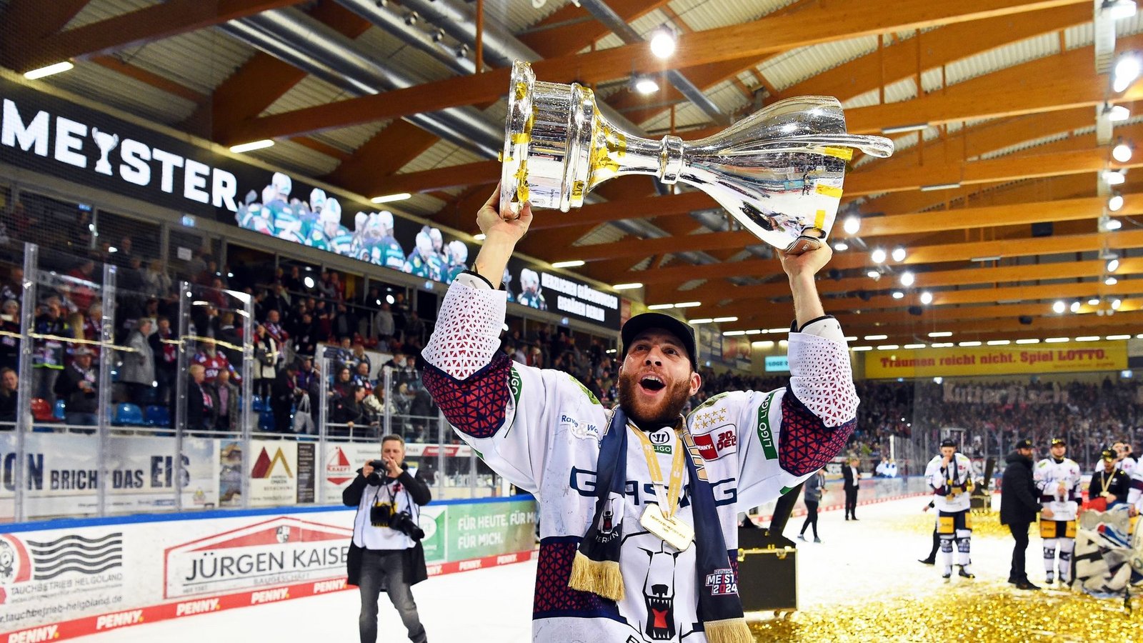 Berlins Yannick Veilleux jubelt nach dem Gewinn der deutschen Eishockey-Meisterschaft mit dem Pokal.Foto: Carmen Jaspersen/dpa