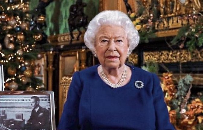 Die britische Monarchin bei der Weihnachtsansprache, die Prunkuhr ist im Hintergrund zu sehen.