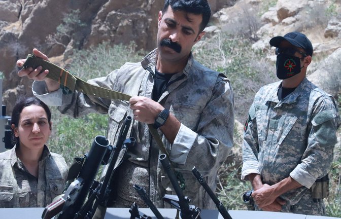 Kämpfer der PKK legten ihre Waffen in  eine Feuerschale. Diese wurden anschließend mit einem brennendem Scheit in Brand gesteckt.<span class='image-autor'>Foto: AFP/Shwan  Mohammed</span>