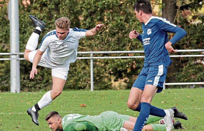 Mit einer artistischen Einlage überspringt Christian Spechtenhauser Merklingens Torwart, der in Illingen den Ball unter sich begräbt. Foto: Küppers