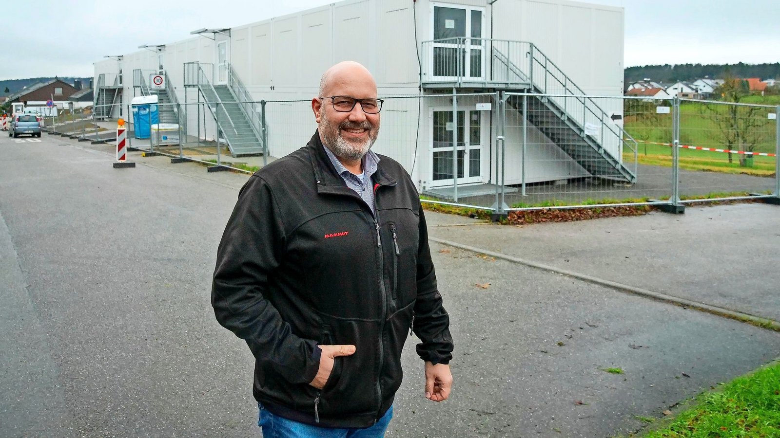 Der Wimsheimer Bürgermeister Mario Weisbrich vor der vom Enzkreis errichteten Container-Anlage am Mühlweg.Foto: /Simon Granville Der Wimsheimer Bürgermeister Mario Weisbrich vor der vom Enzkreis errichteten Container-Anlage am Mühlweg.Foto: /Simon Granville