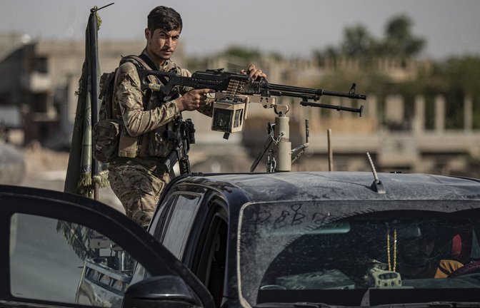 Ein von den USA unterstützter Kämpfer der Syrischen Demokratischen Kräfte (SDF) steht auf einem gepanzerten Fahrzeug in Ostsyrien. Bei Kämpfen im Westen Syrien starben drei Menschen (Archivfoto).<span class='image-autor'>Foto: Baderkhan Ahmad/AP/dpa/Baderkhan Ahmad</span>