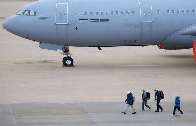 Passagiere des von einem Hantavirus-Ausbruch betroffenen Kreuzfahrtschiffs steigen am Flughafen Eindhoven aus einem Flugzeug aus.<span class='image-autor'>Foto: Christoph Reichwein/dpa</span>