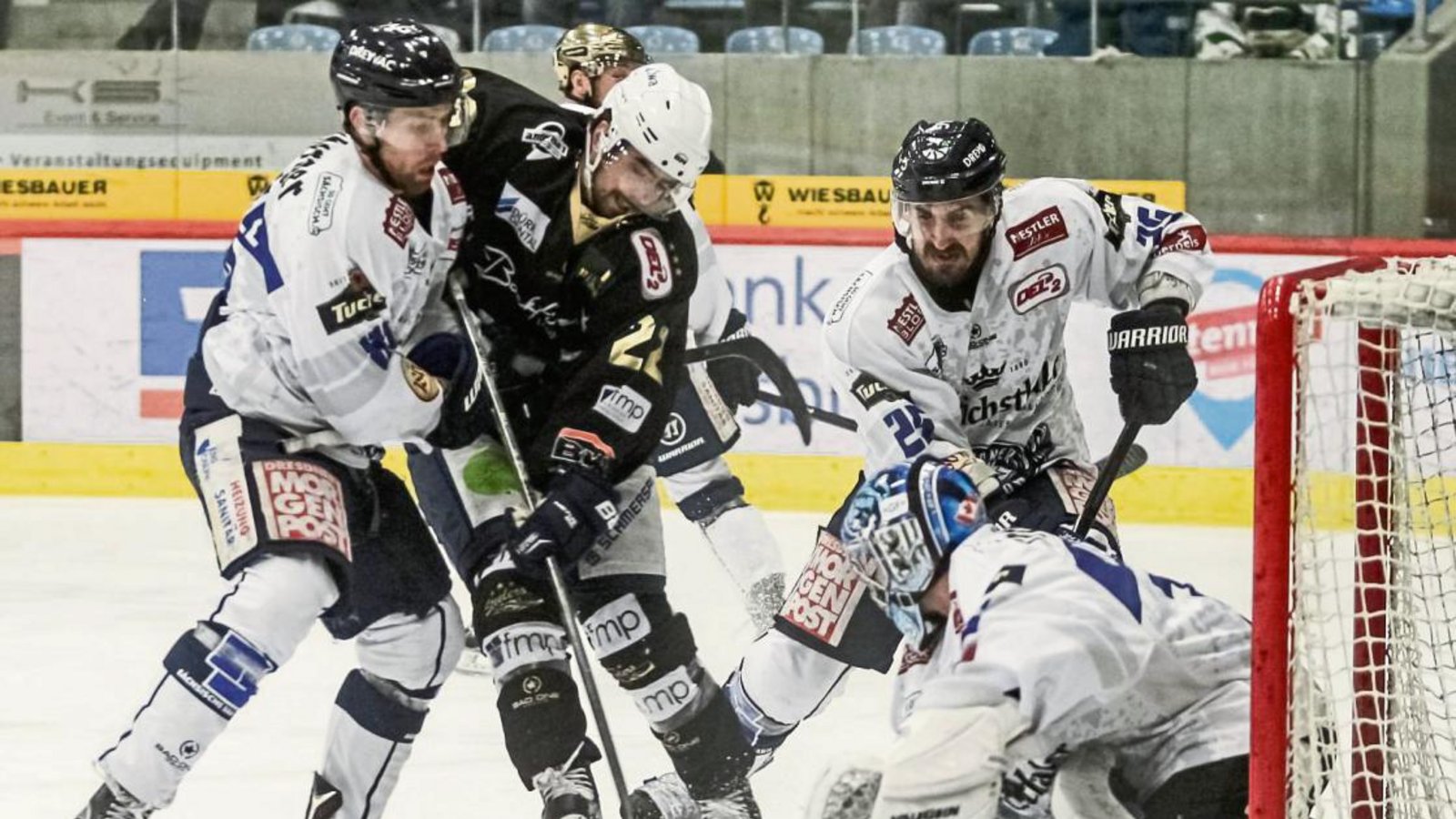 Die Dresdner Max Campbell (links) sowie Goalie Brett Jaeger und Petr Macholda (von rechts) hindern Bietigheims PJ Fenton mit vereinten Kräften am Torabschluss. Foto: Simecek