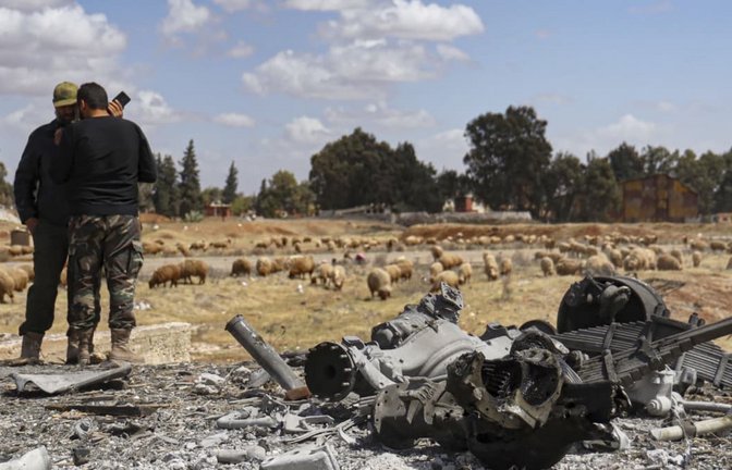 Zwei syrische Armeeoffiziere inspizieren den Ort eines israelischen Angriffs auf einen Militärflughafen in der Nähe von Hama (Archivfoto).<span class='image-autor'>AP</span>
