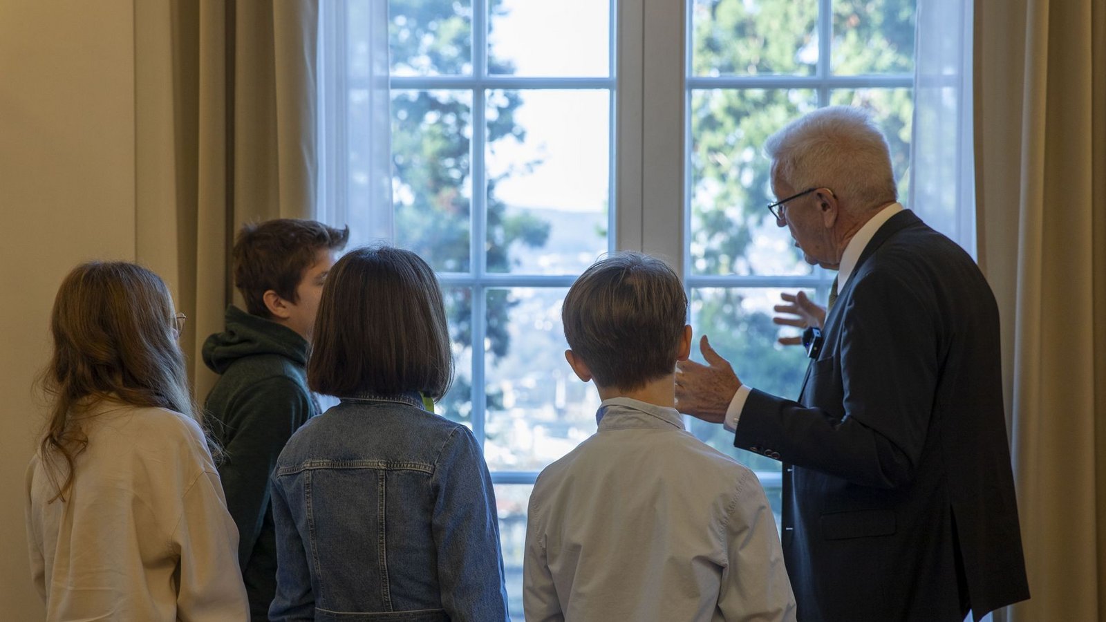 Durch das Fenster zeigt Kretschmann den Kindern die drei beeindruckenden Mammutbäume im Garten.Foto: Lichtgut/Leif Piechowski/Leif Piechowski Durch das Fenster zeigt Kretschmann den Kindern die drei beeindruckenden Mammutbäume im Garten.Foto: Lichtgut/Leif Piechowski/Leif Piechowski