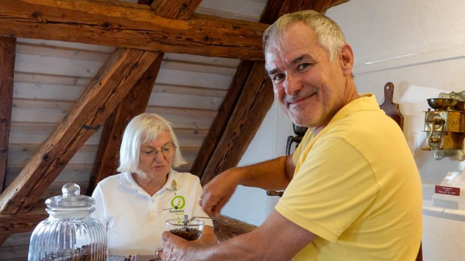 Lia Schatz mit einem Besucher beim Kaffeemahlen und Schätzen. Foto: p Lia Schatz mit einem Besucher beim Kaffeemahlen und Schätzen. Foto: p