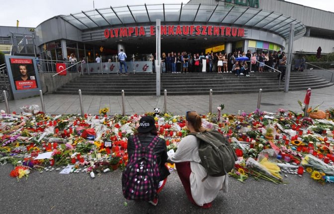 Blumen und Kerzen liegen vor dem Haupteingang des Olympia-Einkaufszentrums (OEZ). Drei Tage zuvor hatte dort ein 18-Jähriger neun Menschen erschossen und sich danach selbst getötet.<span class='image-autor'>Peter Kneffel/dpa</span>