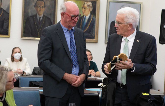 Ein „Veschperbrittle“ (Vesperbrett) zum Abschied: Ministerpräsident Winfried Kretschmann und der beschenkte Sprachforscher Hubert Klausmann (links)<span class='image-autor'>Foto: Universität Tübingen/Friedhelm Albrecht</span>