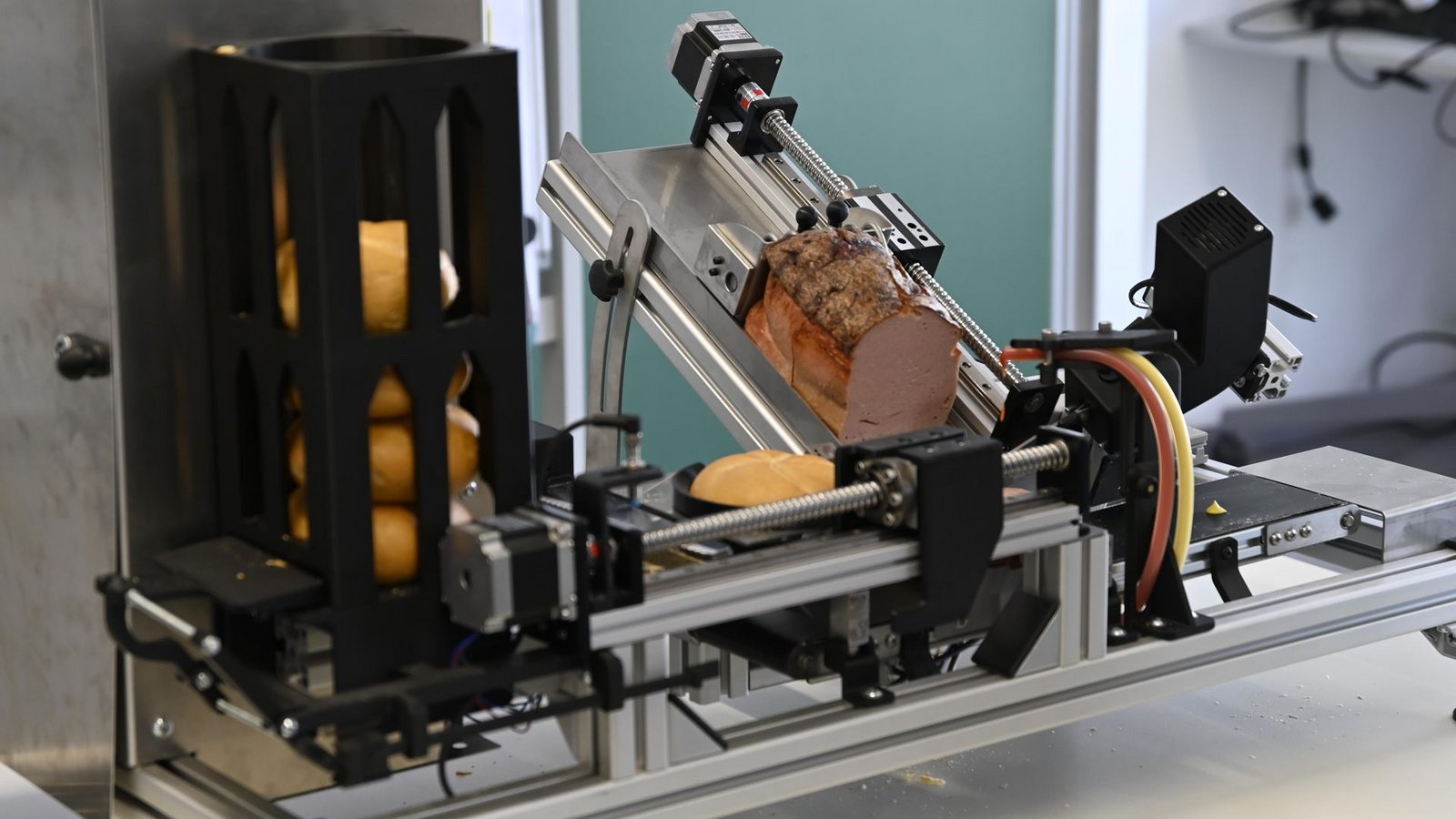 Links werden die Brötchen auf die Reise geschickt, rechts wird der Fleischkäse abgeschnitten und automatisch draufgelegt.Foto: HTWG/Jana Maria Schmid