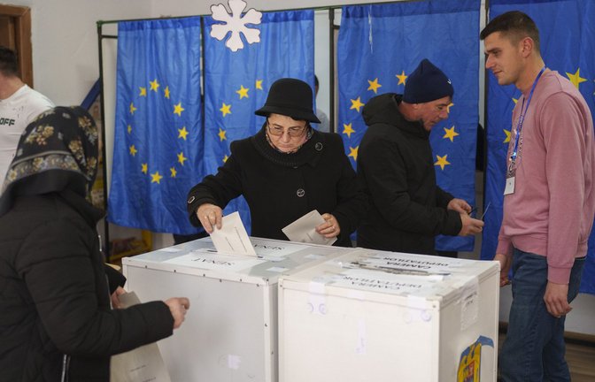 Menschen wählen in einem Wahllokal mit Fahnen der Europäischen Union als Vorhänge für die Kabinen bei den Parlamentswahlen.<span class='image-autor'>Foto: dpa/Vadim Ghirda</span>