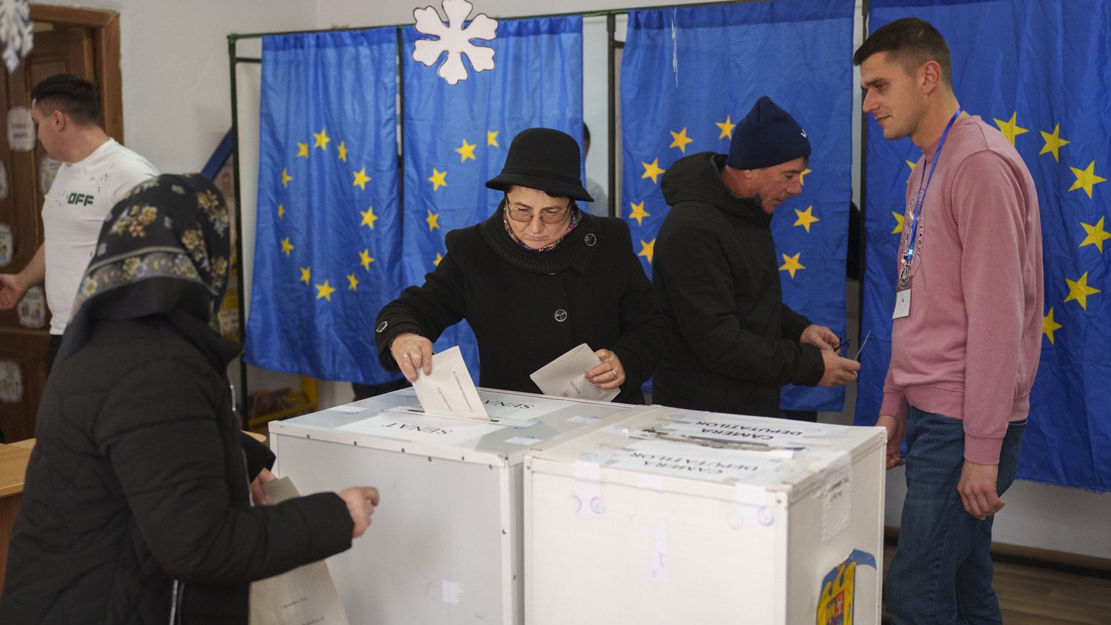Menschen wählen in einem Wahllokal mit Fahnen der Europäischen Union als Vorhänge für die Kabinen bei den Parlamentswahlen.Foto: dpa/Vadim Ghirda Menschen wählen in einem Wahllokal mit Fahnen der Europäischen Union als Vorhänge für die Kabinen bei den Parlamentswahlen.Foto: dpa/Vadim Ghirda