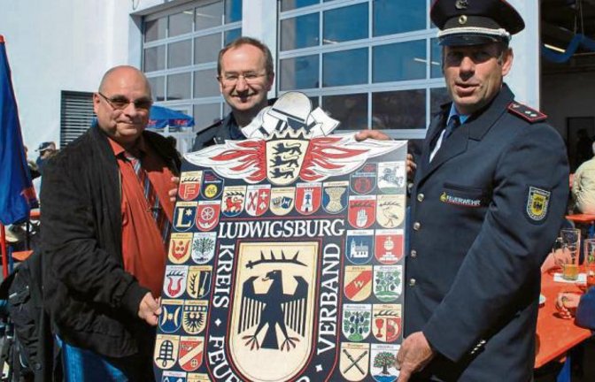 Martin Schäffer (von rechts), stellvertretender Vorsitzender des Kreisfeuerwehrverbandes, überreichte ein Wappenbild an den Kommandanten Achim Neidel und Bürgermeister Jürgen Scholz.