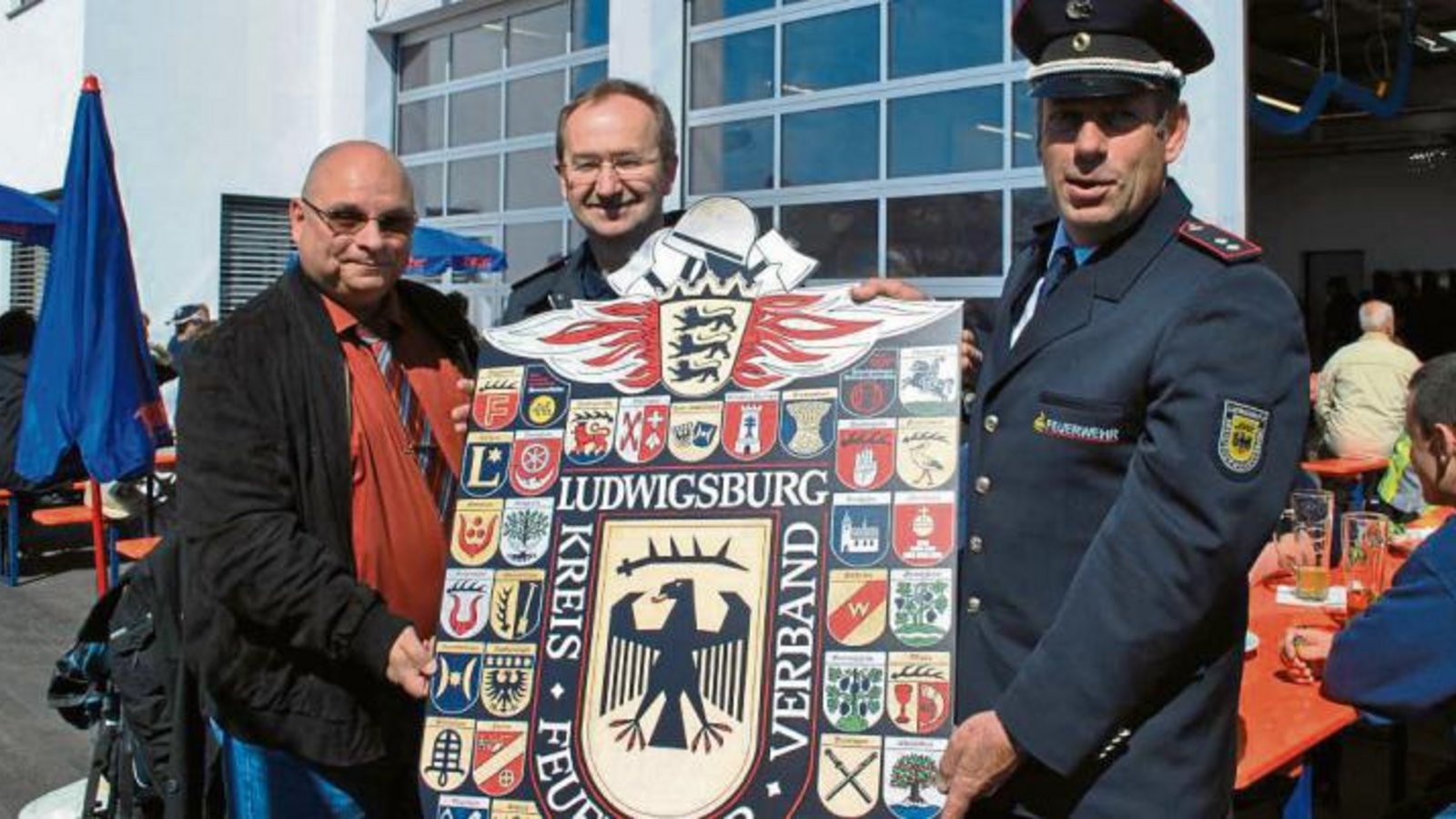 Martin Schäffer (von rechts), stellvertretender Vorsitzender des Kreisfeuerwehrverbandes, überreichte ein Wappenbild an den Kommandanten Achim Neidel und Bürgermeister Jürgen Scholz.