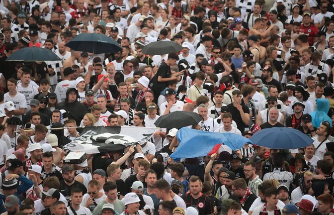 Die Fans der Eintracht stehen bei der Fanparty im Regen.<span class='image-autor'>Foto: dpa/Sebastian Gollnow</span>