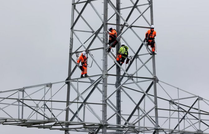 Industriekletterer errichten weithin sichtbar einen Strommasten - Cyberkriminelle dagegen arbeiten im Verborgenen, um unsichtbare Lücken in IT-Systemen für Datenklau auszunutzen. Wie jetzt bei Dienstleistern für Stuttgart Netze und Netze BW.<span class='image-autor'>IMAGO/Rene Traut</span>