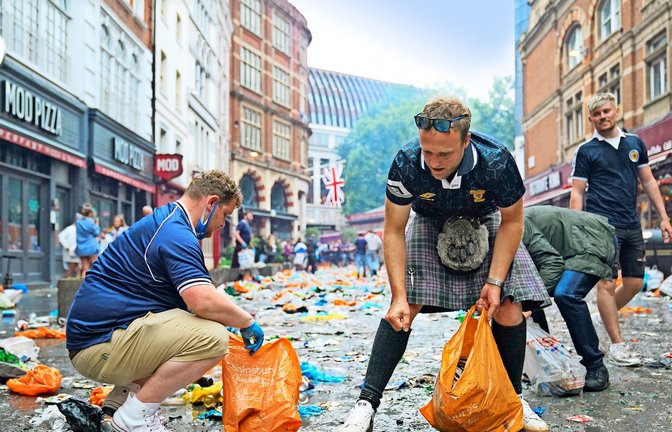 Vorbildlich: Schottische Fans sammeln nach einem Vorrundenspiel den Müll von der Straße<span class='image-autor'>Foto: dp/Kirsty O'Connor</span>