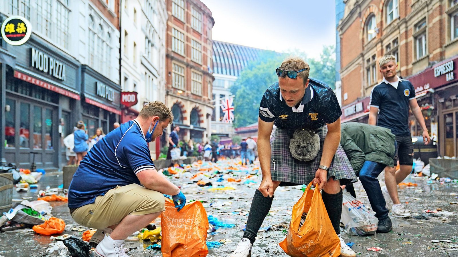 Vorbildlich: Schottische Fans sammeln nach einem Vorrundenspiel den Müll von der StraßeFoto: dp/Kirsty O'Connor Vorbildlich: Schottische Fans sammeln nach einem Vorrundenspiel den Müll von der StraßeFoto: dp/Kirsty O'Connor