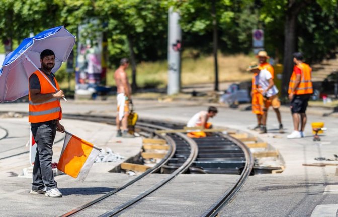 Schirm, Hut, Kleidung – gerade auf Baustellen sind die Mittel begrenzt, mit denen Mitarbeiter, wie hier im Stuttgarter Osten, den starken Temperaturen und Sonnenstrahlen vorbeugen können.<span class='image-autor'>Christoph Schmidt/dpa</span>