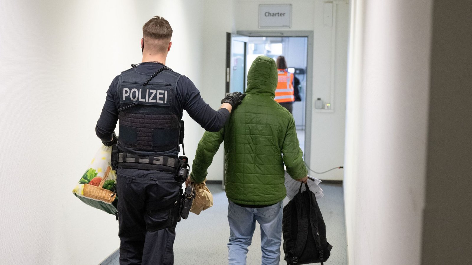 Ein Polizeibeamter bringt einen Mann zu einem Abschiebeflug (Symbolbild).Foto: dpa/Boris Roessler