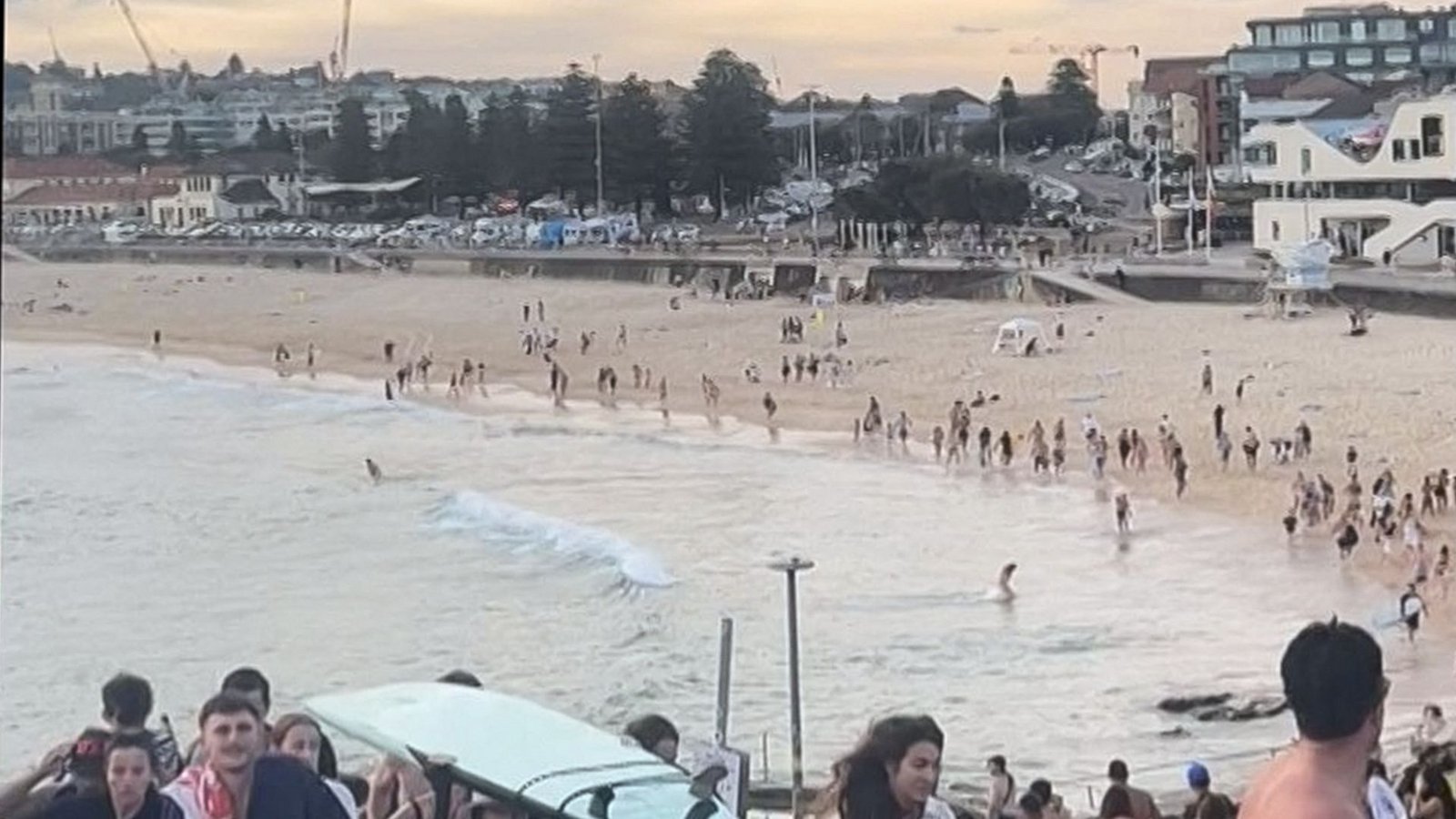 Dieser Bildschirmmitschnitt eines am 14. Dezember 2025 aufgenommenen und von Mike Ortiz zur Verfügung gestellten UGC-Videos zeigt Strandbesucher, die vom Bondi Beach fliehen, nachdem bewaffnete Täter das Feuer eröffnet hatten, in Sydney am 14. Dezember 2025.Foto: AFP