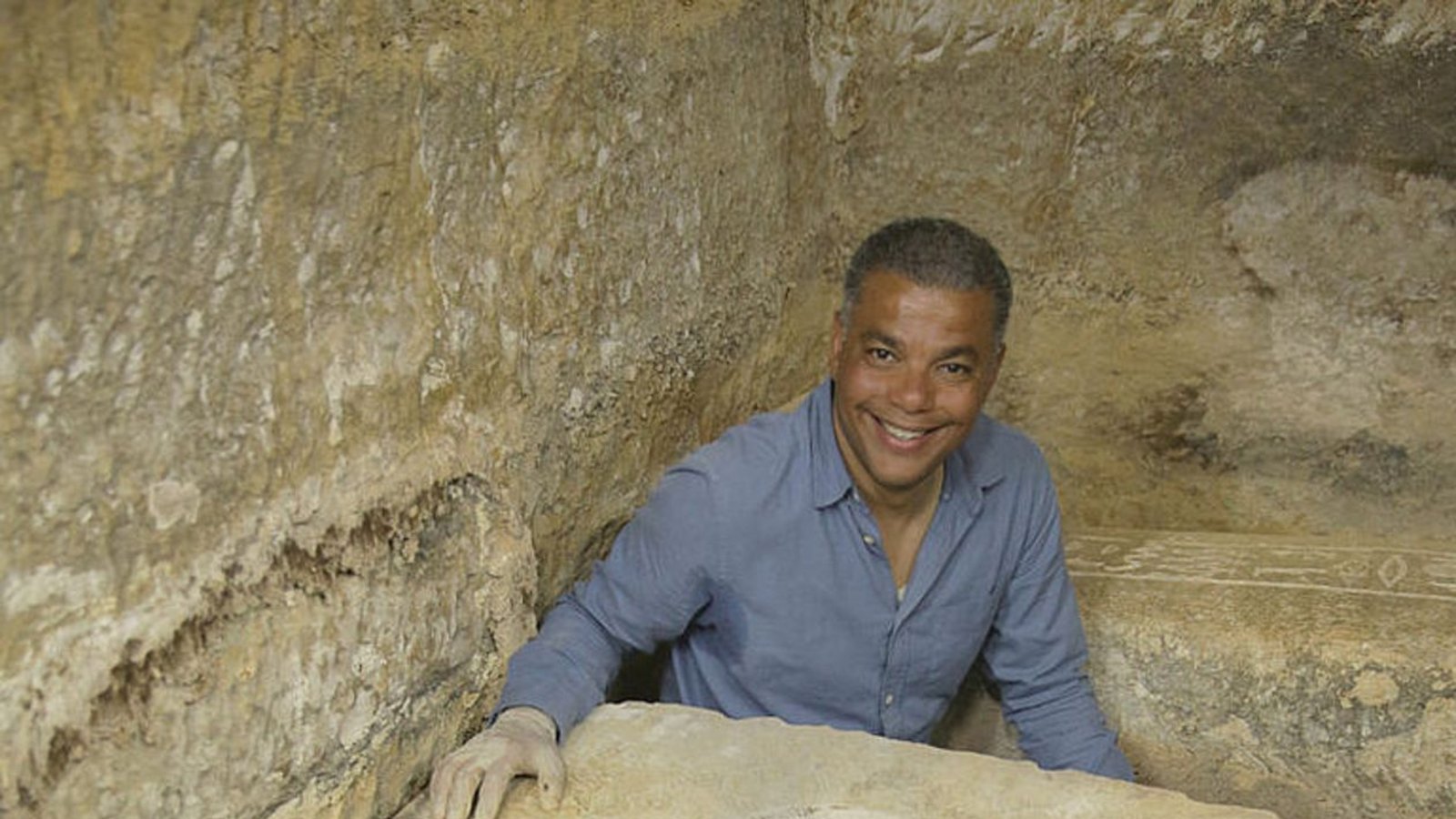 Ramadan Hussein mit der Mumie des Priesters Tjanimit. Die dunkle Farbe der Umhüllungen ist wahrscheinlich eine Dichtungsschicht aus Bitumen oder Harz. Das dekorative Perlennetz ist mit Goldfolie aufgefädelt.Foto: Saqqara Saite Tombs Project/eScience Center/Universität Tübingen Ramadan Hussein mit der Mumie des Priesters Tjanimit. Die dunkle Farbe der Umhüllungen ist wahrscheinlich eine Dichtungsschicht aus Bitumen oder Harz. Das dekorative Perlennetz ist mit Goldfolie aufgefädelt.Foto: Saqqara Saite Tombs Project/eScience Center/Universität Tübingen