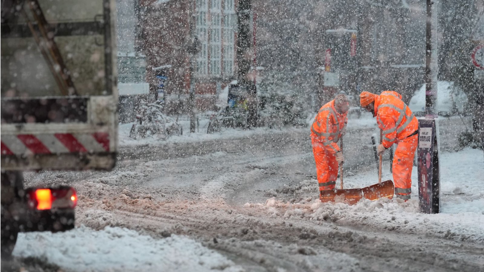 Mitarbeiter des Winterdienstes räumen in Hamburg den Schnee von einem schneebedeckten Zebrastreifen und Fußgängerübergang.Foto: Marcus Brandt/dpa