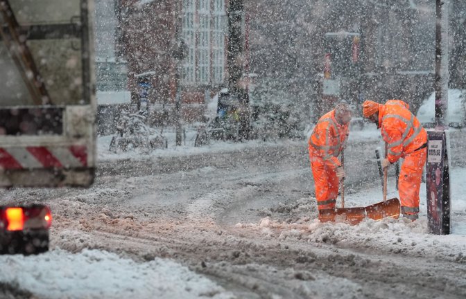 Mitarbeiter des Winterdienstes räumen in Hamburg den Schnee von einem schneebedeckten Zebrastreifen und Fußgängerübergang.<span class='image-autor'>Foto: Marcus Brandt/dpa</span>