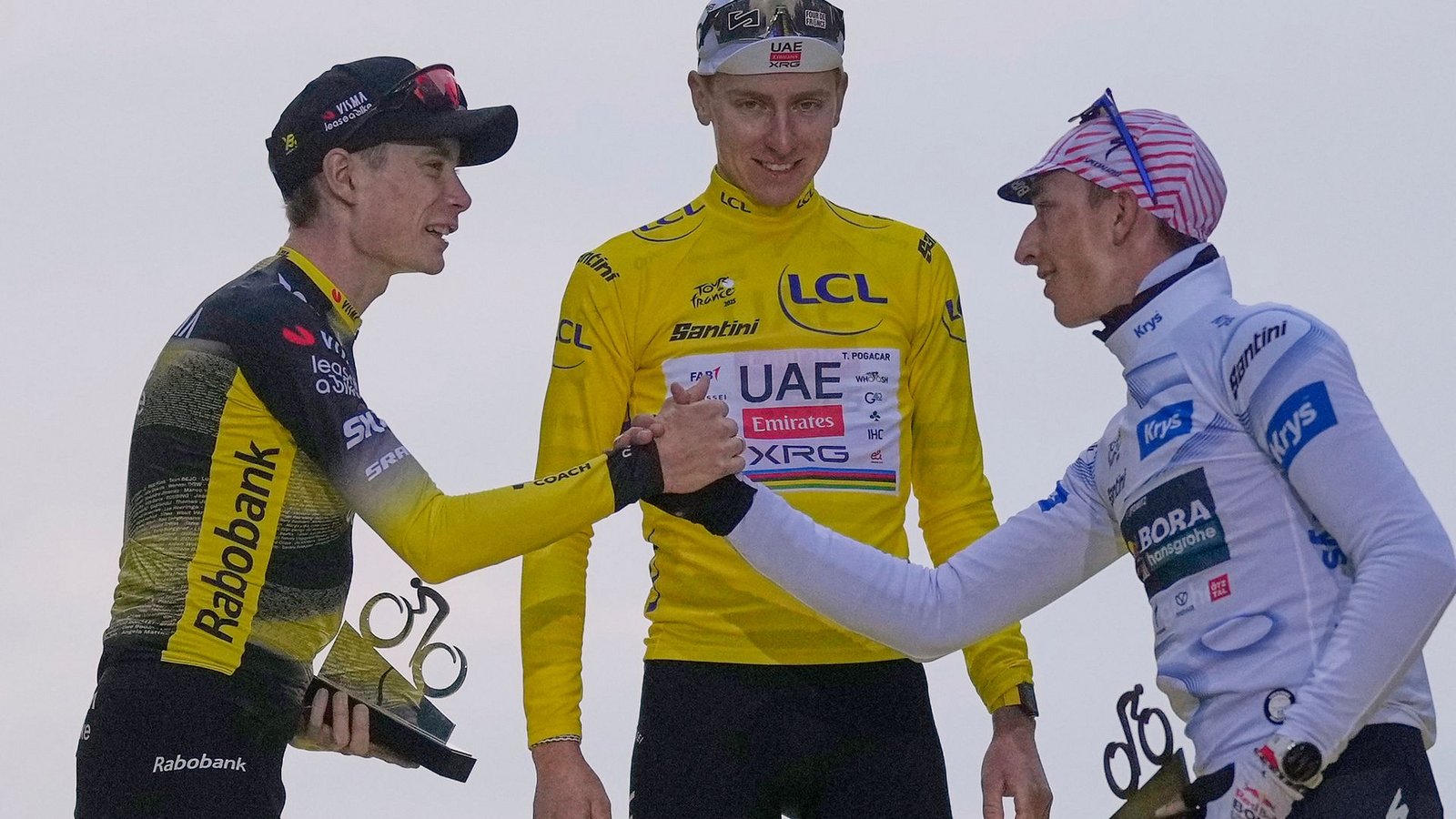 Standen im letzten Jahr auf dem Podium: Vingegaard (l), Lipowitz (r) und Sieger Pogacar. (Archivbild)Foto: Mosa'ab Elshamy/AP/dpa