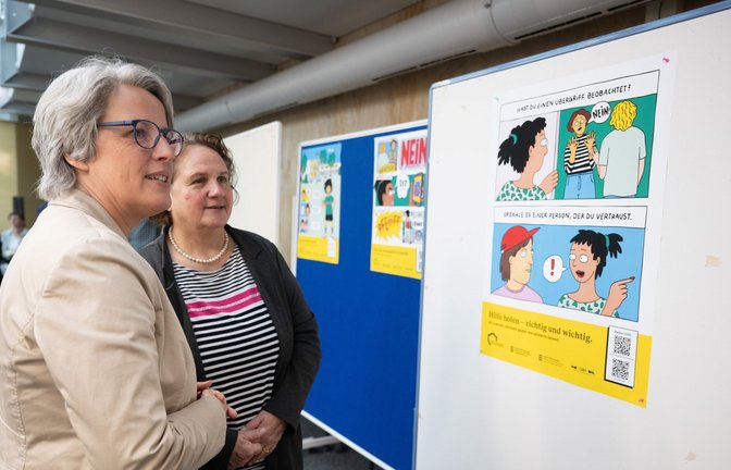 Kerstin Claus (links) und Theresa Schopper schauen ein Plakat gegen sexualisierte Gewalt an.<span class='image-autor'>Foto: dpa/Marijan Murat</span>