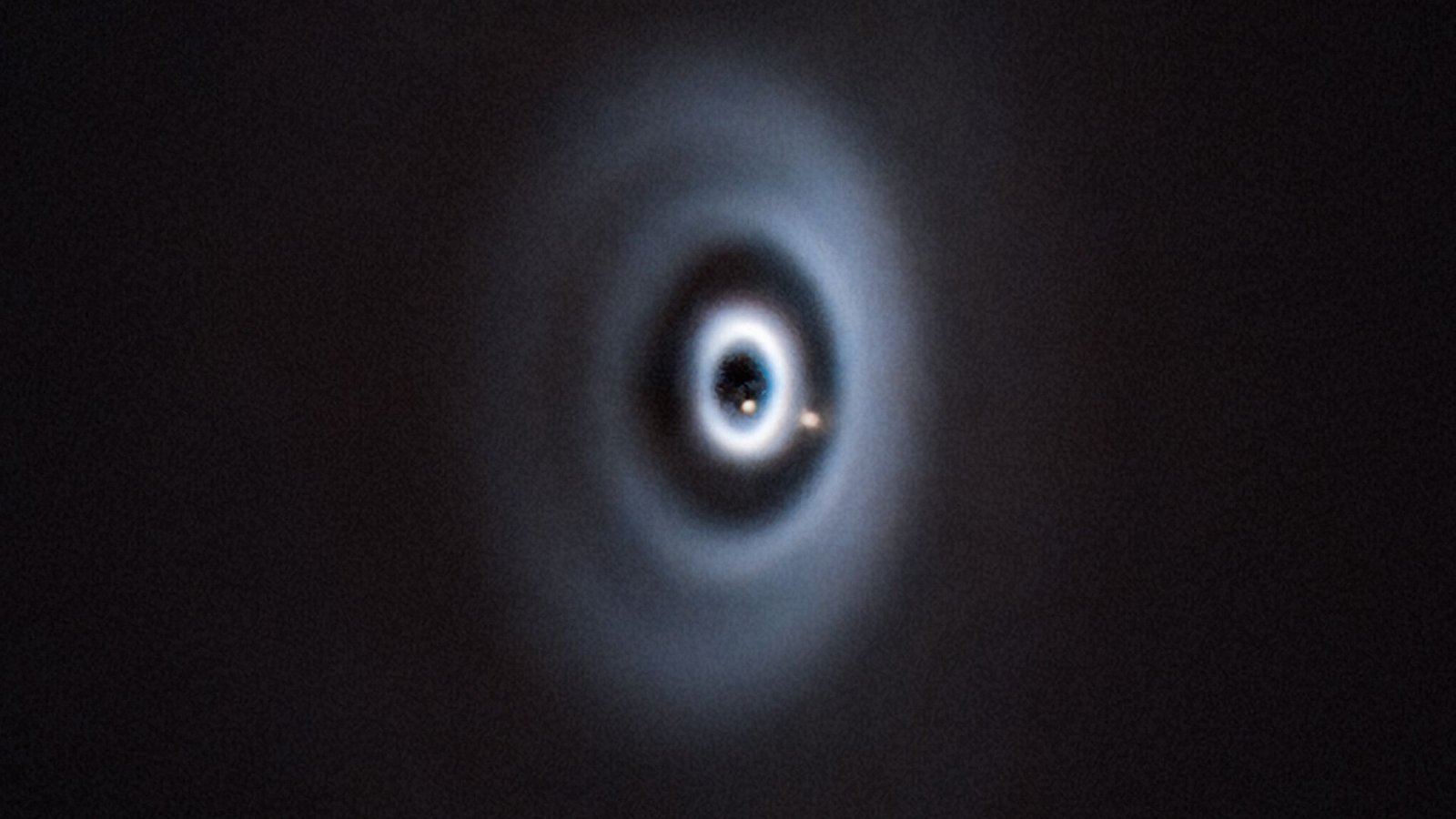 Etwa so könnte es bei der Entstehung der Erde in unserem Sonnensystem ausgesehen haben. Geburt von zwei Planeten (beige Punkte) in einer protoplanetaren Scheibe um den jungen Stern WISPIT 2.Foto: ESO CC 4.0/C. Lawlor, R. F. van Capel Etwa so könnte es bei der Entstehung der Erde in unserem Sonnensystem ausgesehen haben. Geburt von zwei Planeten (beige Punkte) in einer protoplanetaren Scheibe um den jungen Stern WISPIT 2.Foto: ESO CC 4.0/C. Lawlor, R. F. van Capel