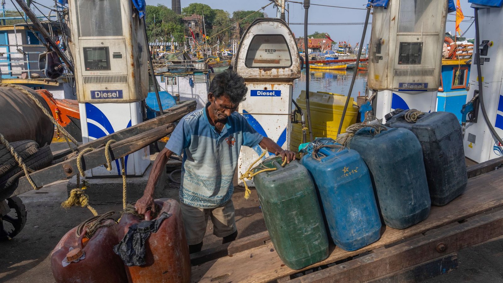 Ein indischer Arbeiter ordnet leere Treibstoffkanister auf seinem Handkarren im Hafen von Mumbai.Foto: Rafiq Maqbool/AP/dpa
