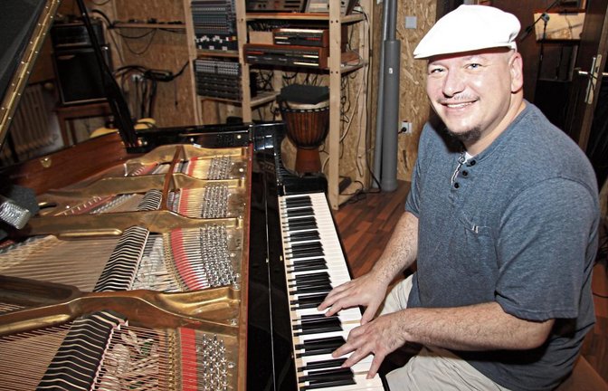 Die weiße Mütze ist sein Markenzeichen: Michael Fiedler bei der Arbeit in seinem privaten Tonstudio.  Foto: Banholzer