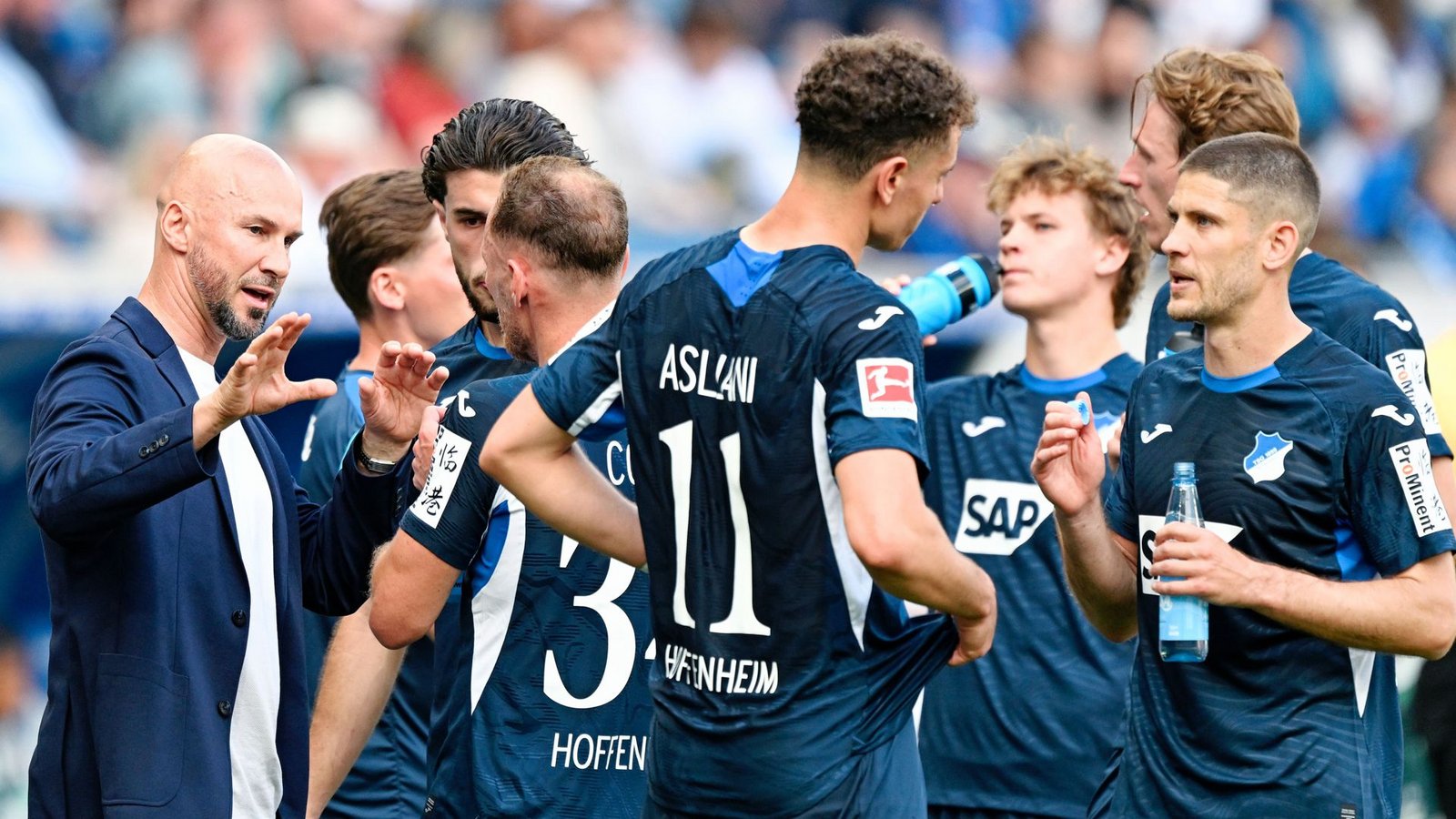 Trainer Christian Ilzer (l, 1899 Hoffenheim) spricht mit seinen Spielern. Für Hoffenheim ist das Rennen um einen Champions-League-Platz noch nicht vorbei.Foto: Uwe Anspach/dpa/Uwe Anspach Trainer Christian Ilzer (l, 1899 Hoffenheim) spricht mit seinen Spielern. Für Hoffenheim ist das Rennen um einen Champions-League-Platz noch nicht vorbei.Foto: Uwe Anspach/dpa/Uwe Anspach