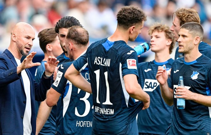 Trainer Christian Ilzer (l, 1899 Hoffenheim) spricht mit seinen Spielern. Für Hoffenheim ist das Rennen um einen Champions-League-Platz noch nicht vorbei.<span class='image-autor'>Foto: Uwe Anspach/dpa/Uwe Anspach</span>