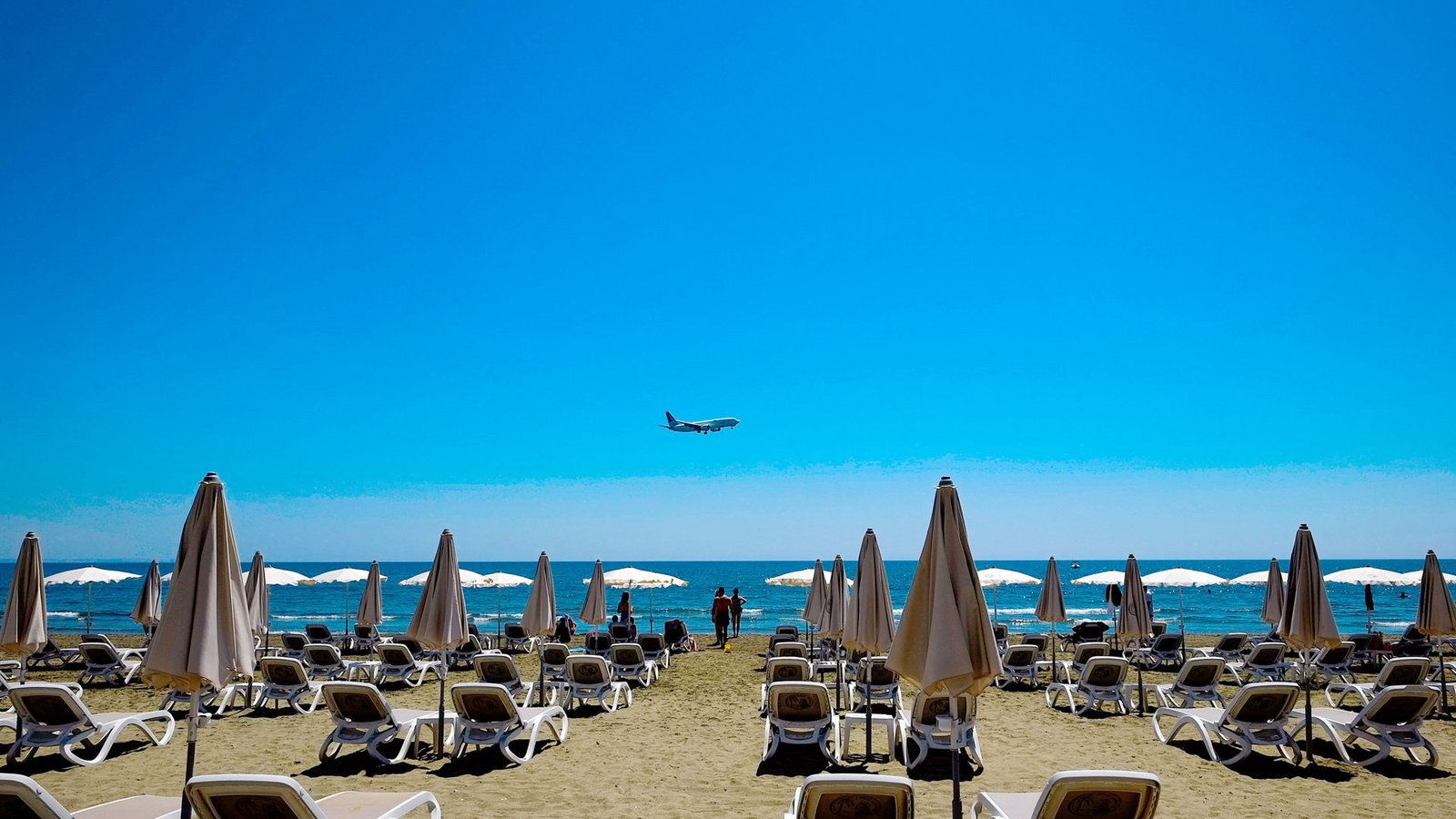 Sonne am Strand von Larnaka in Zypern. Im Hintergrund ein Flugzeug im Anflug auf den Flughafen.Foto: dpa/Petros Karadjias Sonne am Strand von Larnaka in Zypern. Im Hintergrund ein Flugzeug im Anflug auf den Flughafen.Foto: dpa/Petros Karadjias